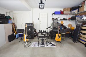 Rock band music equipment in a cluttered suburban garage.